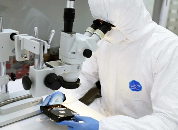 Technician examining a device to perform data recovery services